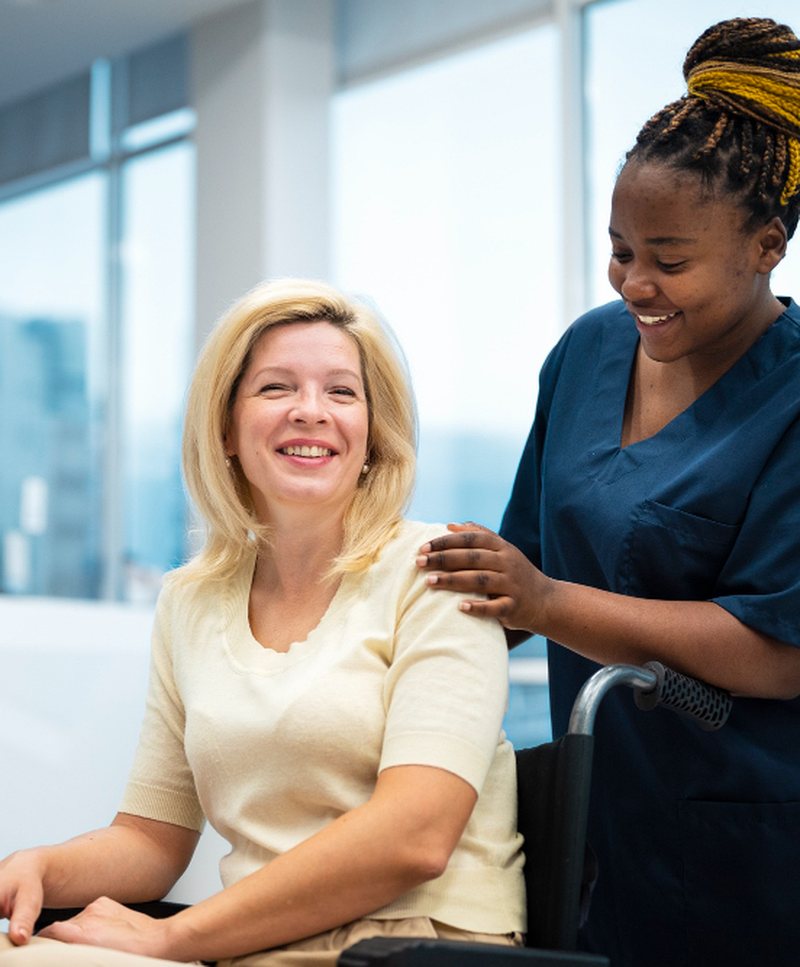 A caregiver resting a reassuring hand on a seated client's shoulder