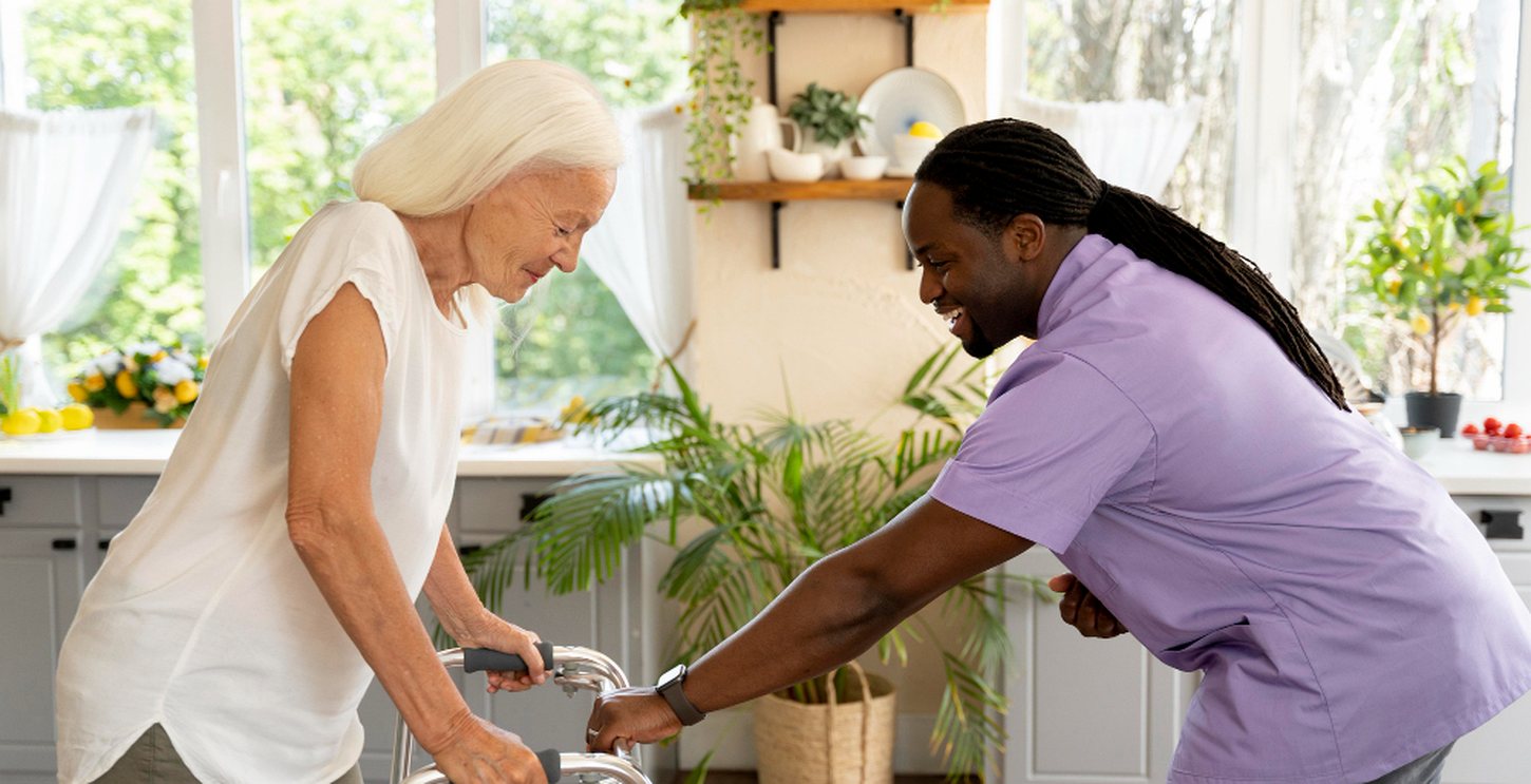 A caregiver supporting a client using a walking frame at home